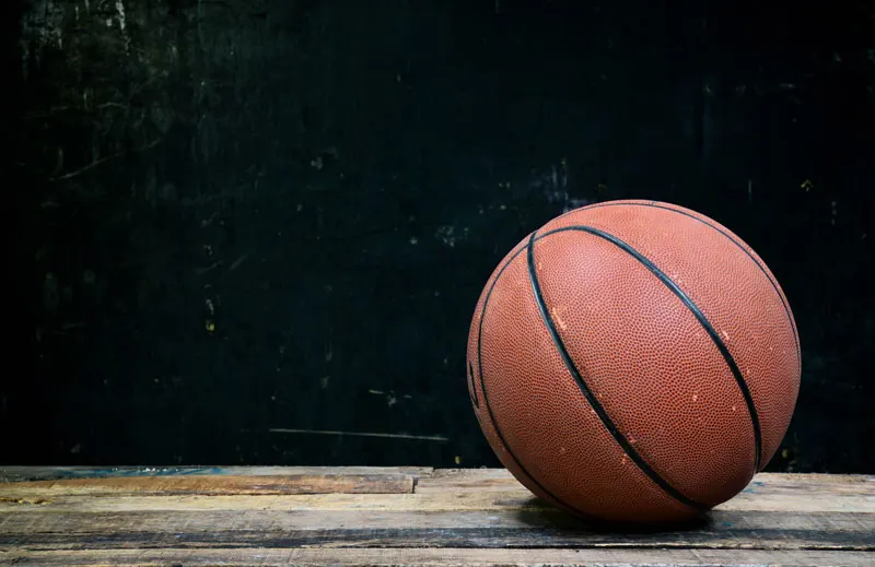 A basketball on a wooden floor.
