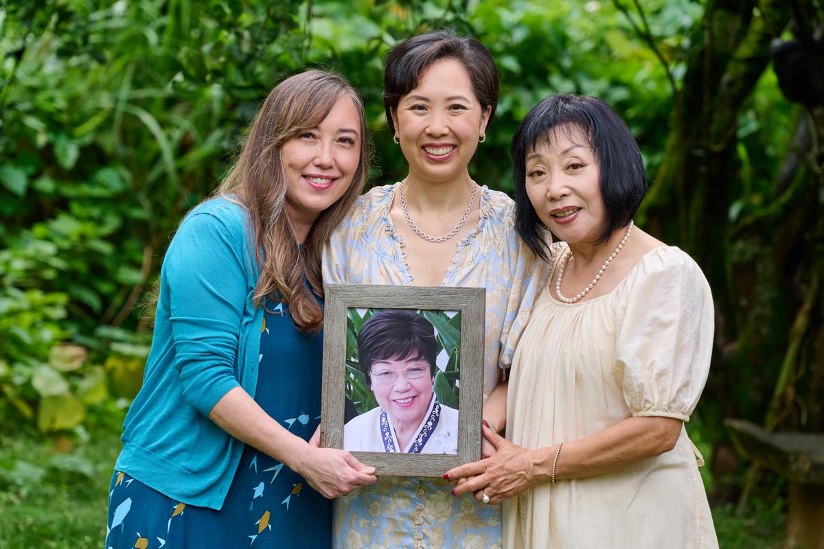 Mother and her two daughters holding a picture frame.