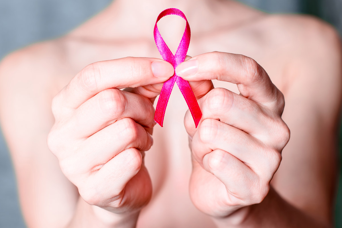 A woman holding up a cancer ribbon.
