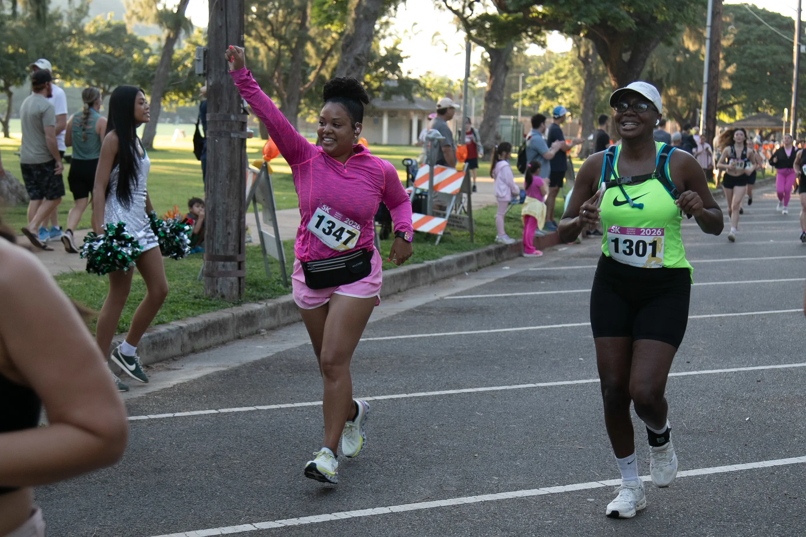 Two 5K participants smiling as they pass the cheering crowds.