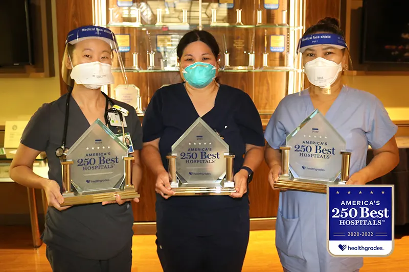 Three Straub medical professionals holding Healthgrades awards.