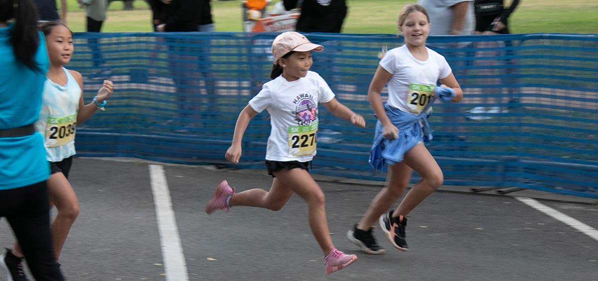 Girls smile as they cross the finish line.