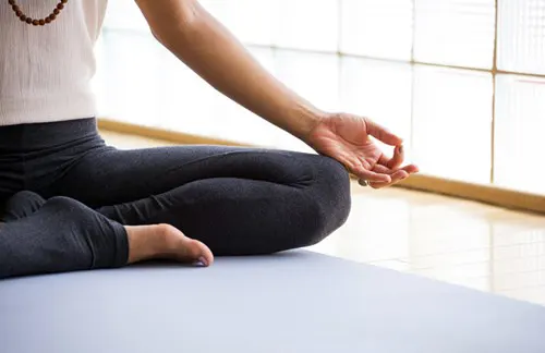 A person sits in the lotus position. 