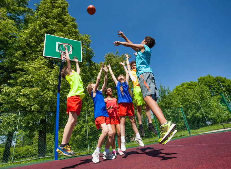 A handful of adolescent kids playing basketball.