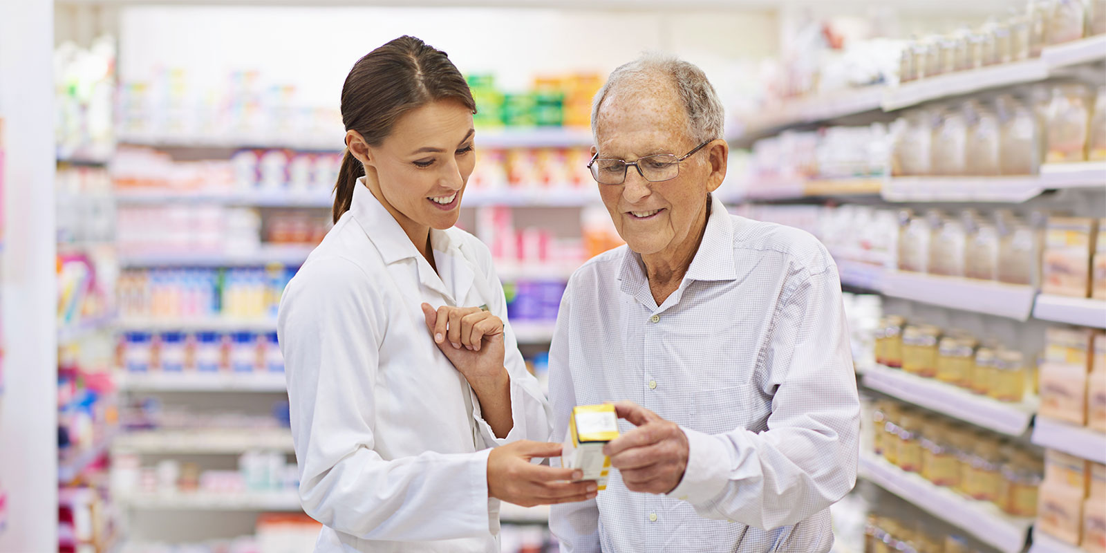 Pharmacist with older man discussing his medication.