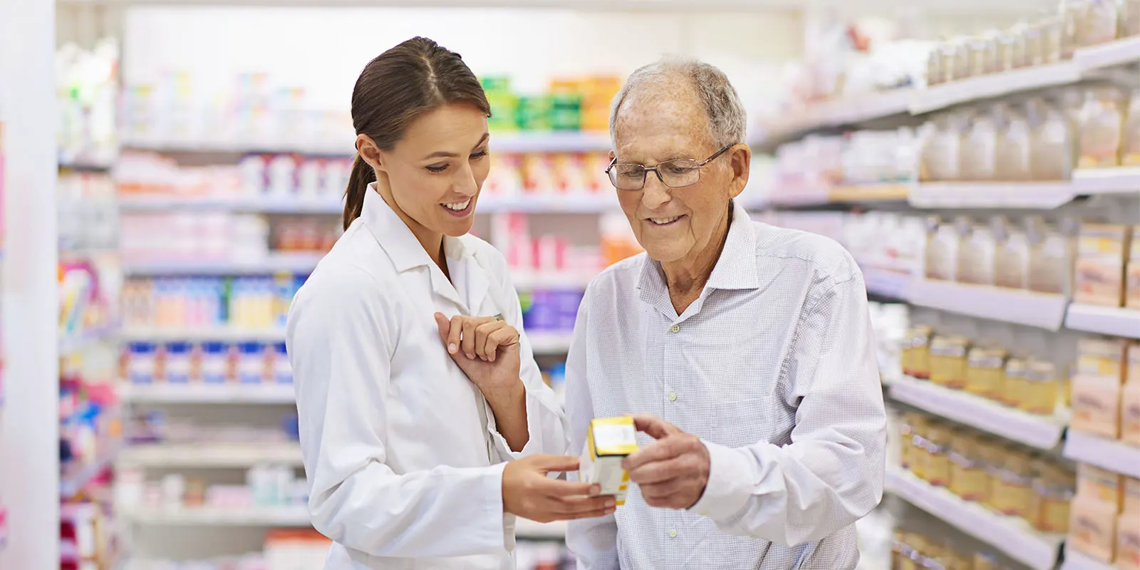 Pharmacist with older man discussing his medication.