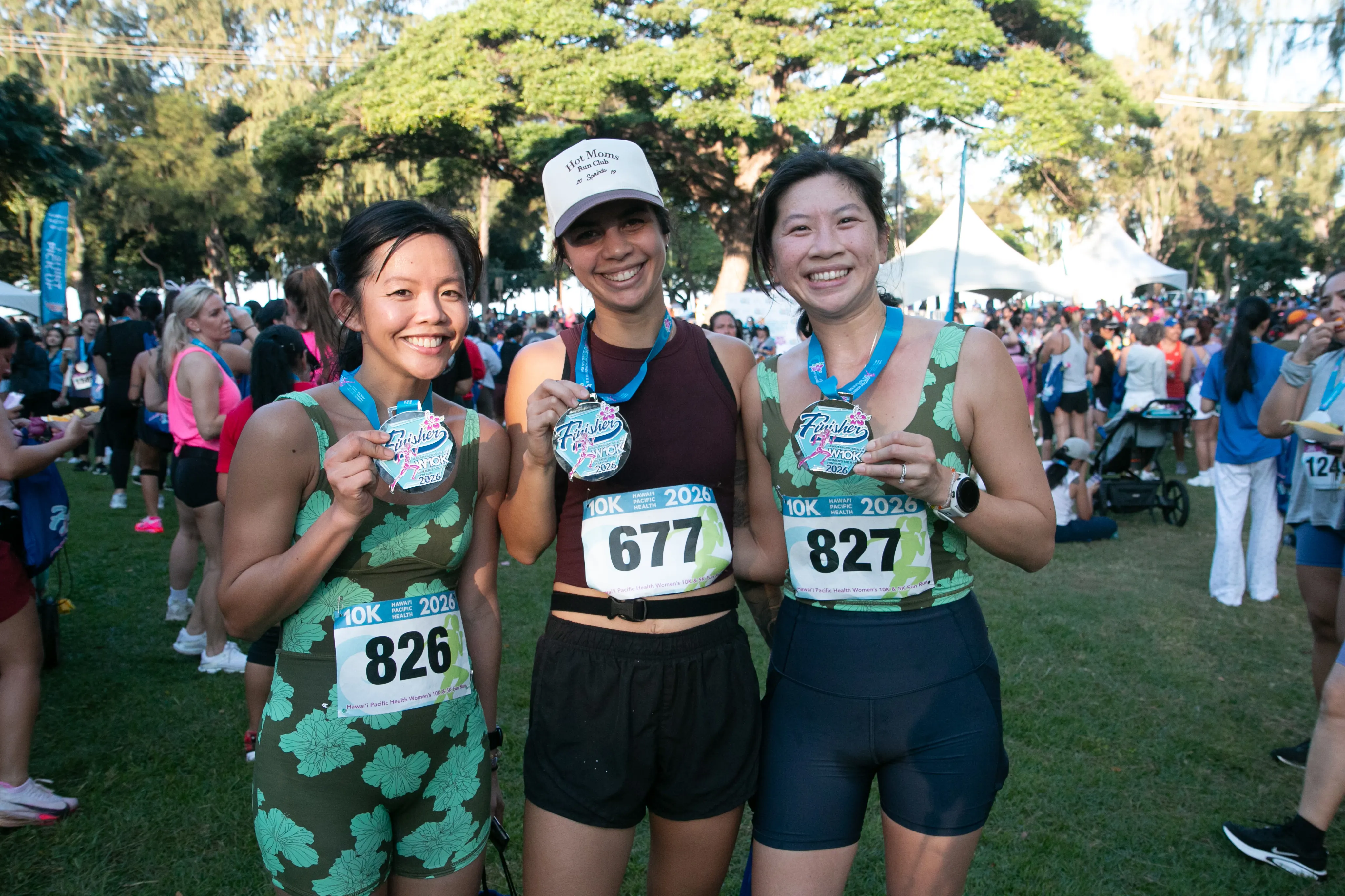 Three 10K finishers smiling with their finisher medals.
