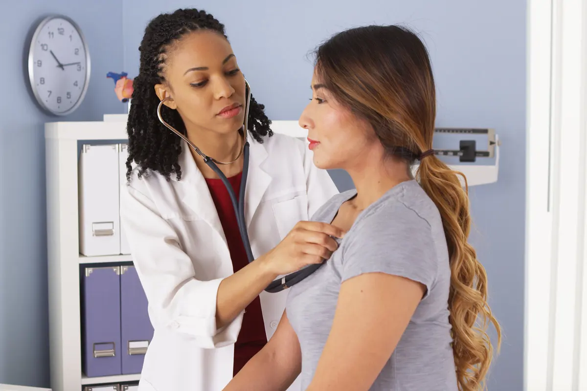 A woman getting her heart examined by doctor.