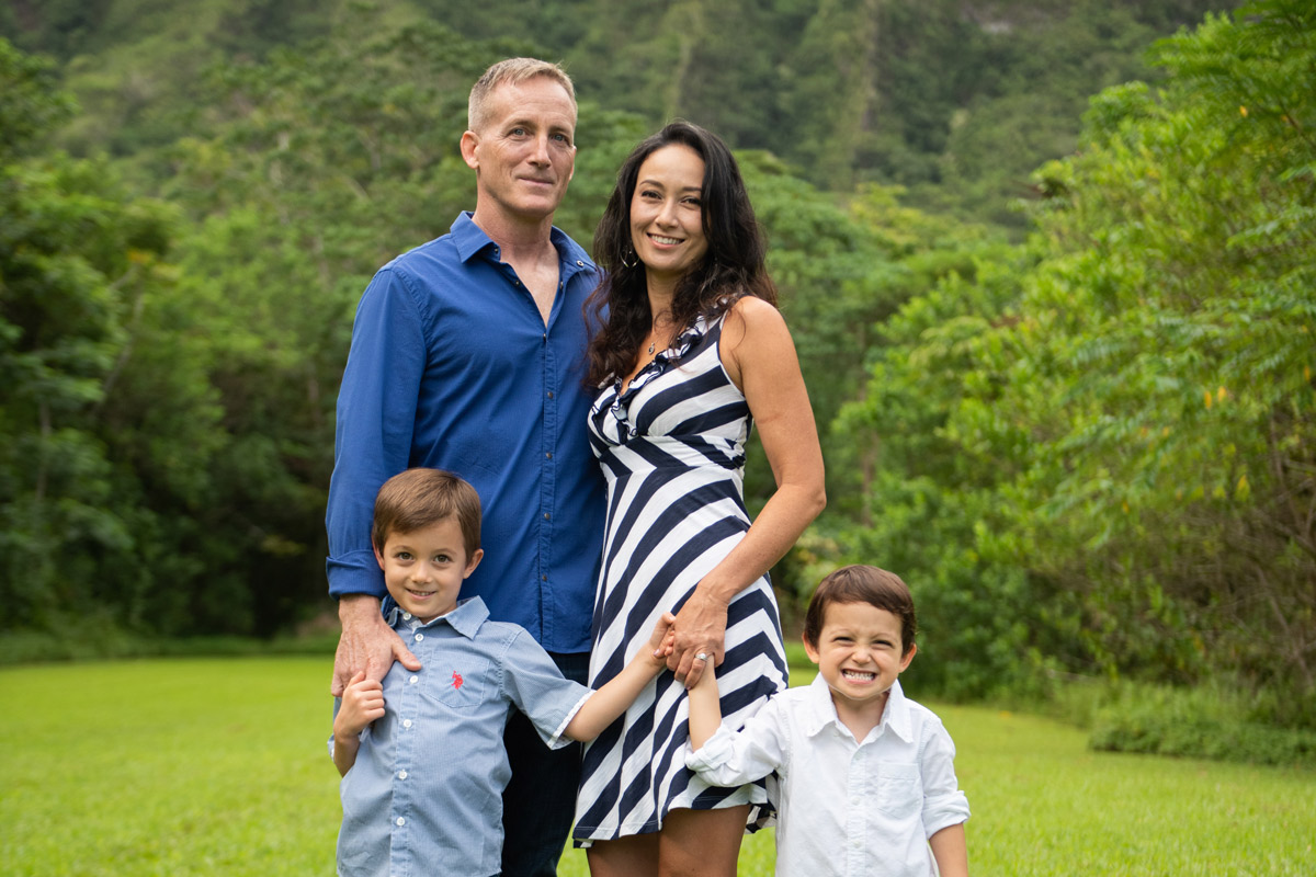 Father smiling with his wife and their two sons.