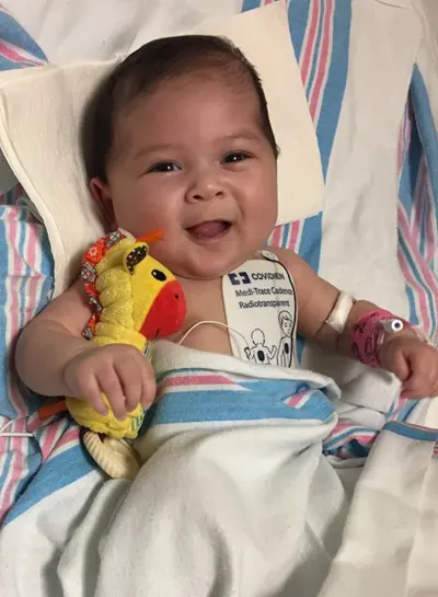 Baby laughing and holding a toy giraffe. 