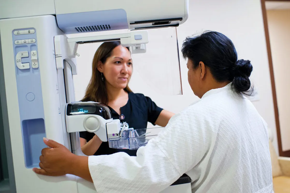 A patient getting a mammogram performed by doctor.