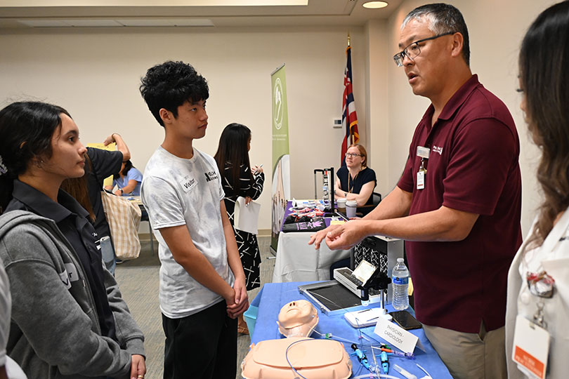 Doctor talking to a small group of students at a career fair.  