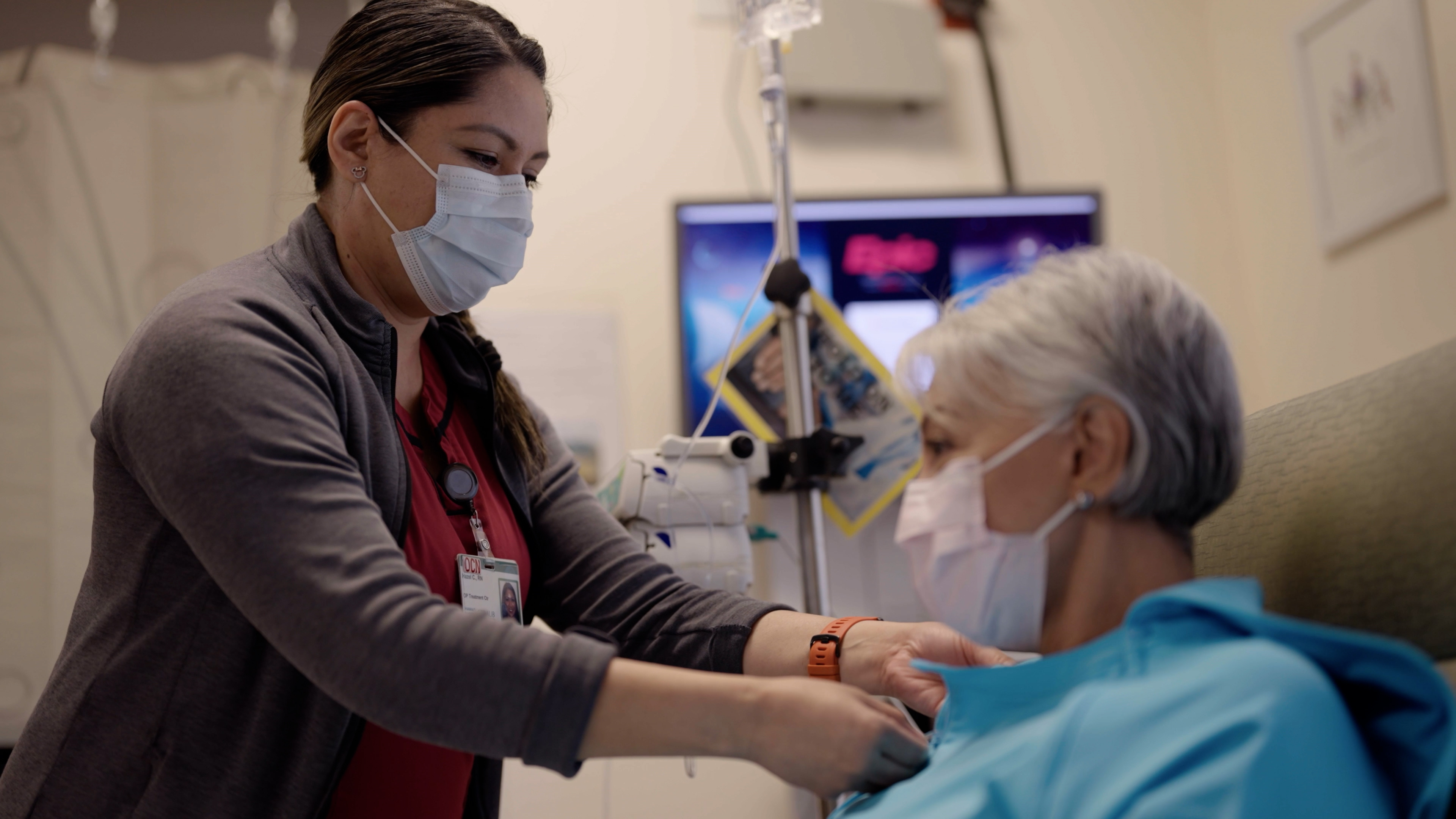 Provider making adjustments for a cancer patient about to receive treatment.