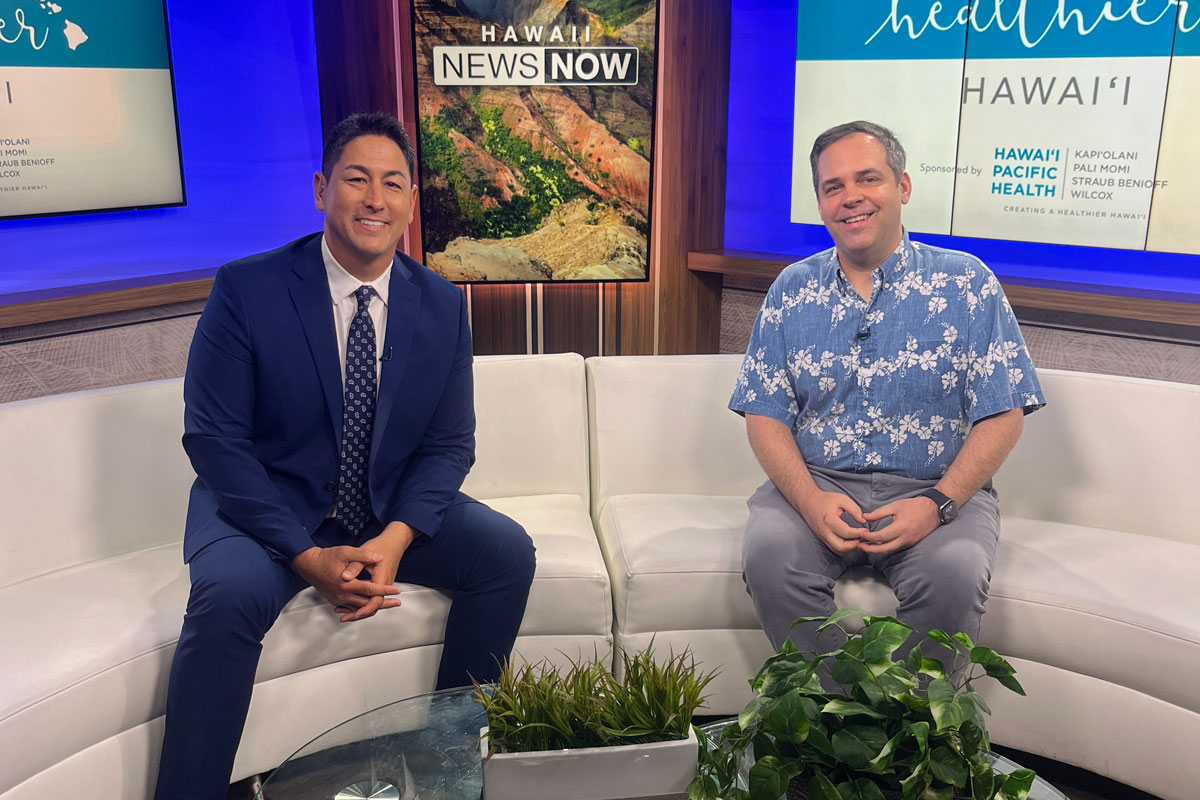 Two smiling men sitting on couches on the set of a morning news show on Hawaii News Now.