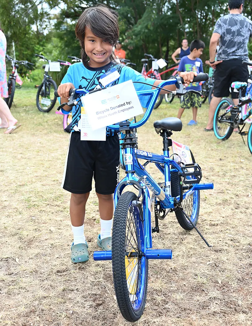 young child with a blue bicycle.