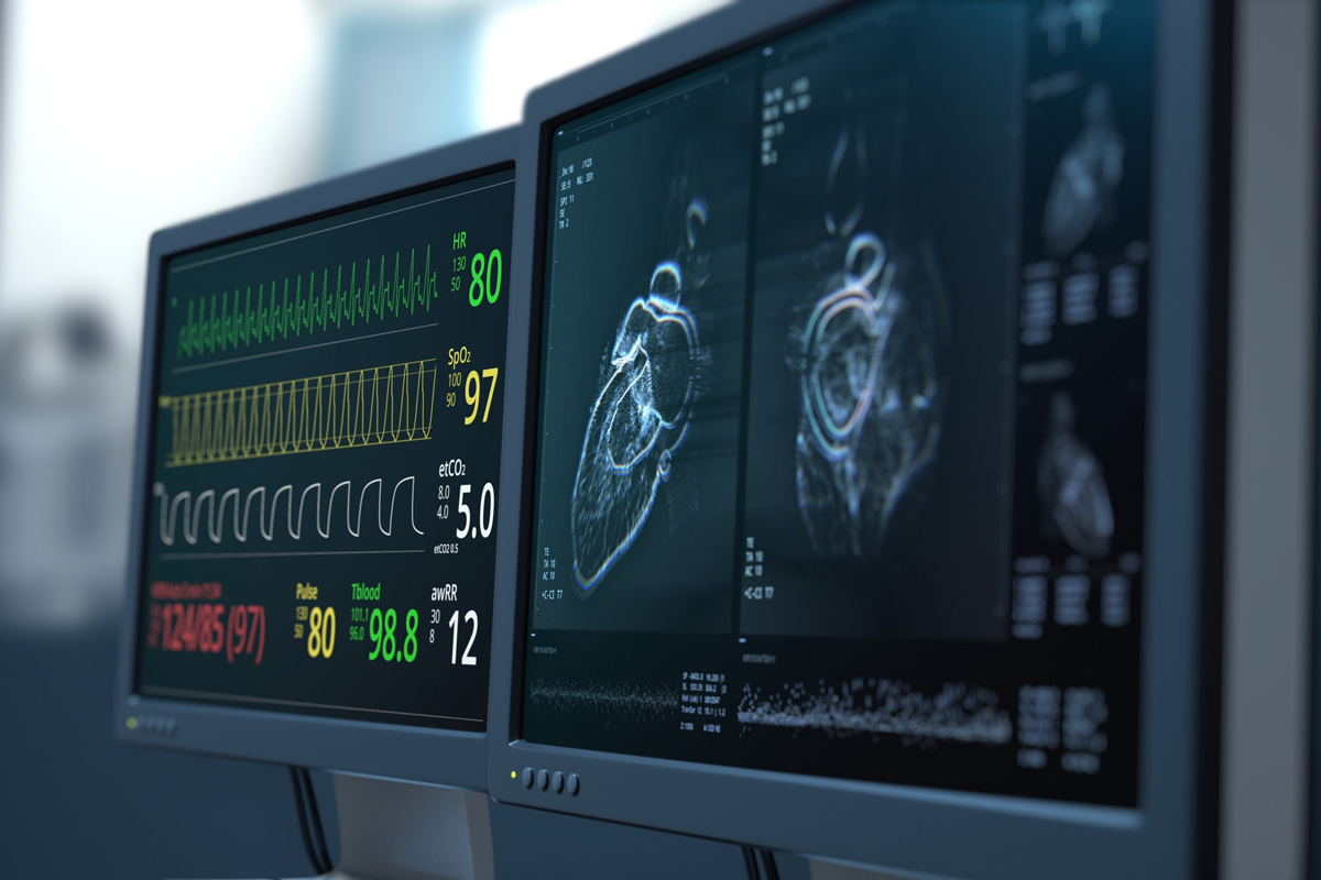Medical monitors display a patient's vital signs and a scan of a heart.