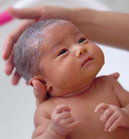 Baby receiving their first bath.