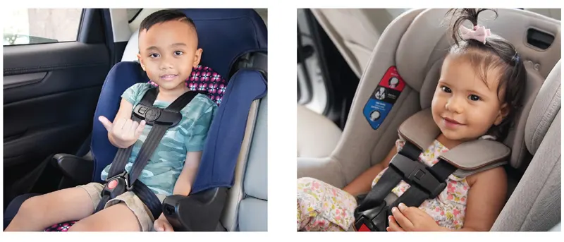 Two children safely sitting in their car seat and smiling.