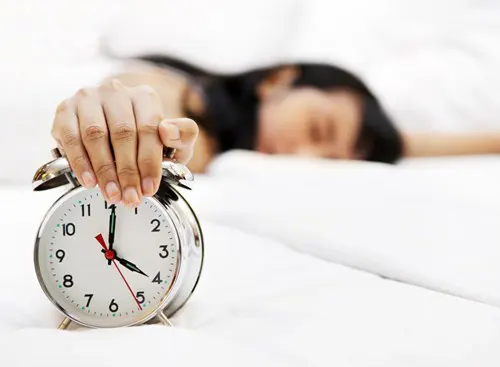 A person snoozing an alarm clock.