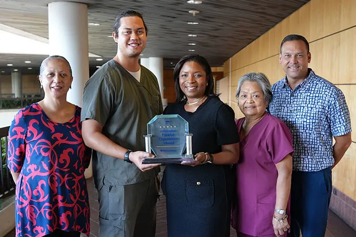 Pali Momi leadership and team members holding the Healthgrades 2022 Outstanding Patient Experience Award.