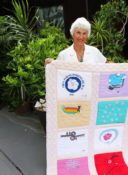 Woman holding her handmade quilt.