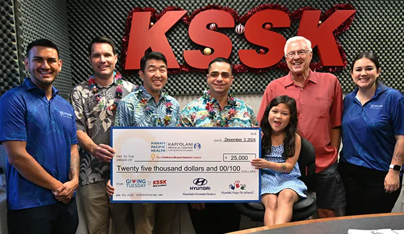 Group in front of a KSSK sign with a giant check for $25,000.