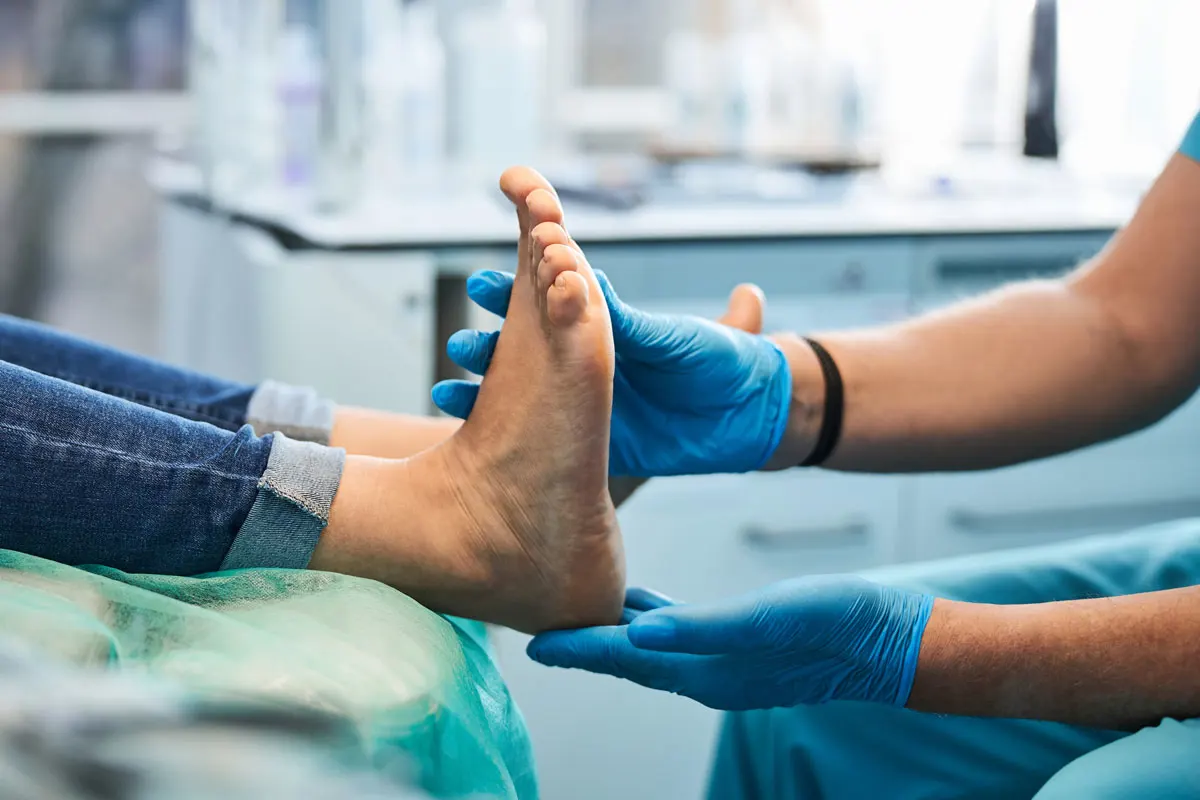 A doctor examines a patient's feet.