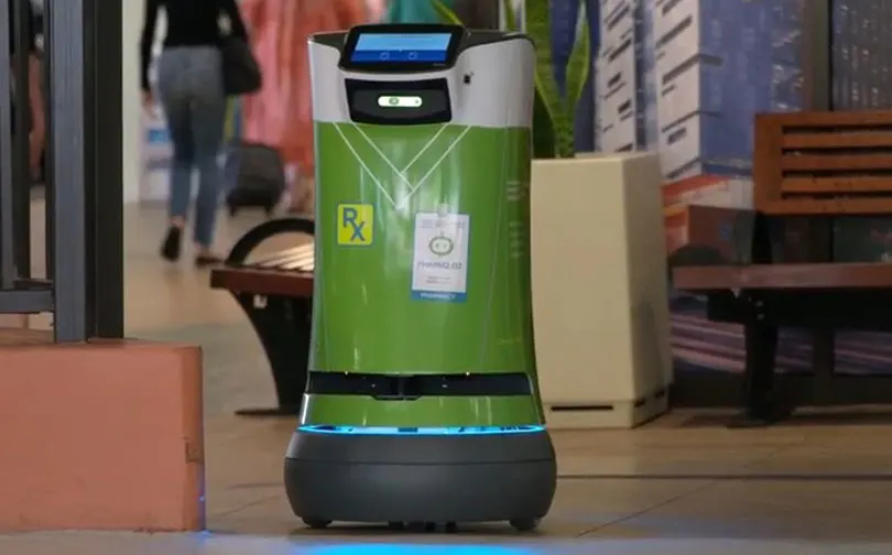small green robot en route to deliver medications from the pharmacy.
