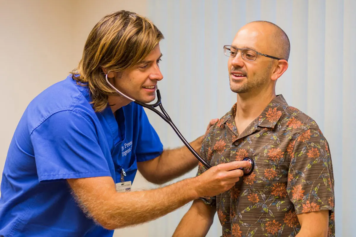 A doctor examining his patient with a stethoscope.