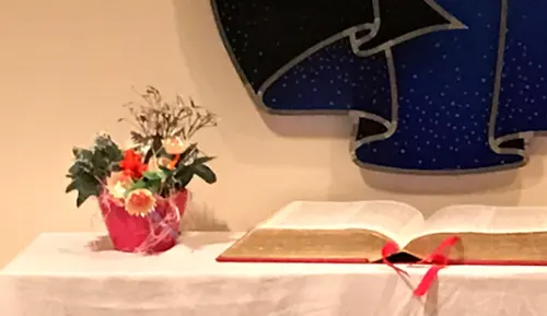 Bible and flowers on a small shelf at Wilcox Medical Center chapel.