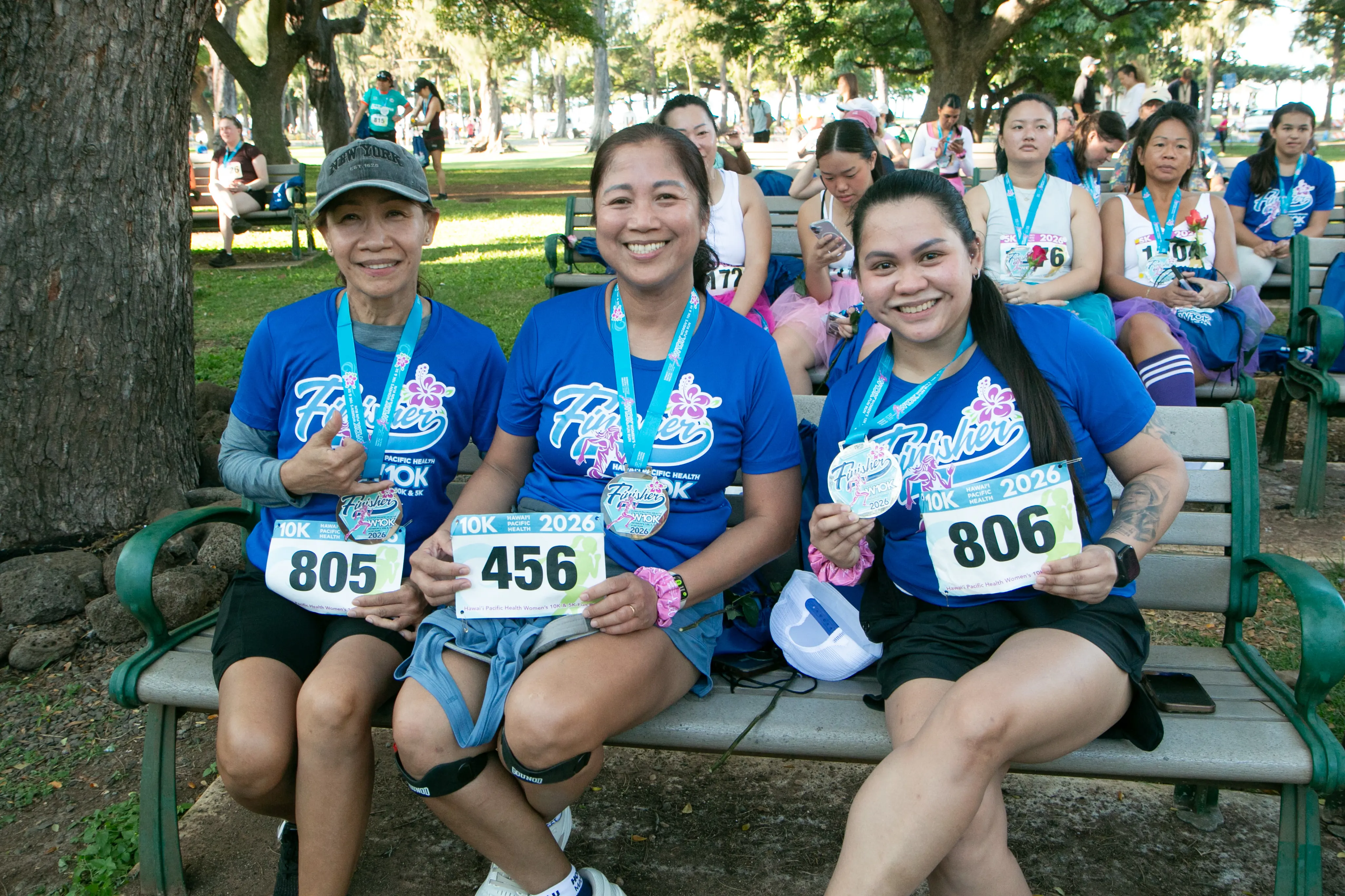 10K finishers smiling with their bib and finisher medal.