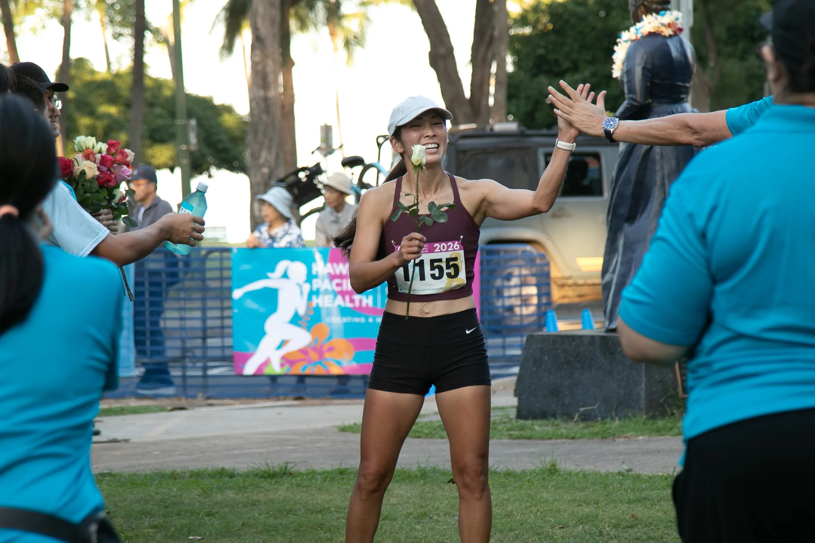 5K finisher receiving her rose and high fiving someone.