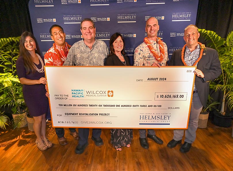Donors, Hawaiʻi Pacific Health and Wilcox leadership, and the Hawaiʻi Gov. standing with a giant check for $10.6 million.