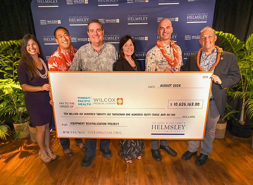 Donors, Hawaiʻi Pacific Health and Wilcox leadership, and the Hawaiʻi Gov. standing with a giant check for $10.6 million.