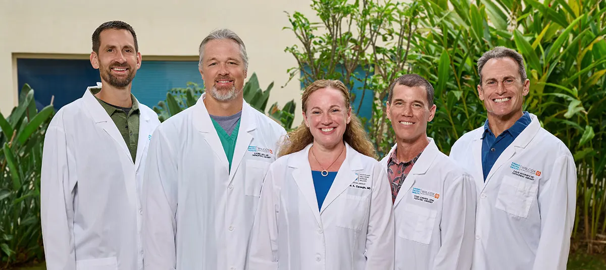 Group shot of physicians in white coats smiling.