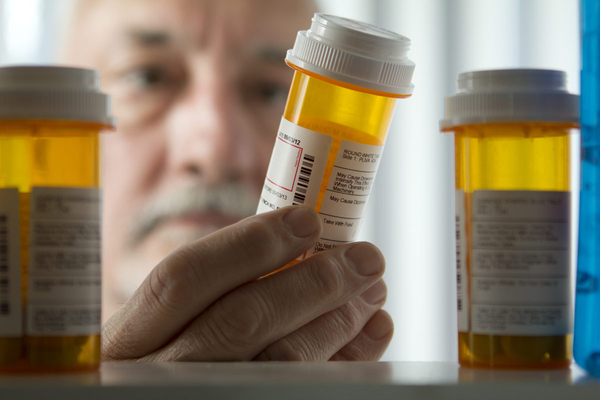 A doctor examining the contents of a prescription bottle.