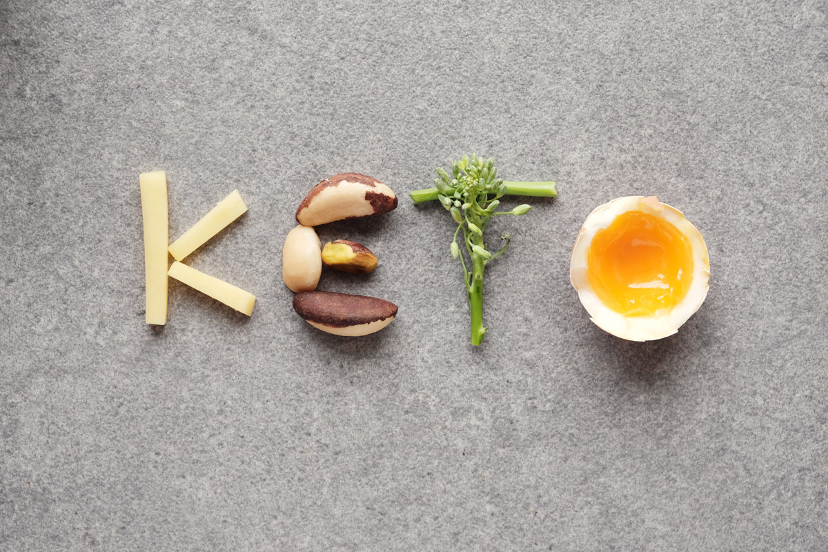 Cheese, nuts, broccoli and a soft-boiled egg spell out the word "KETO"