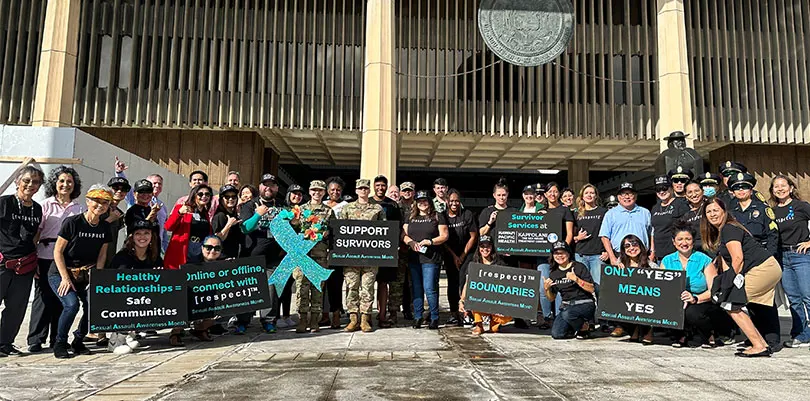 Large group shot of people gathered to sign-wave in support of sexual assault awareness.