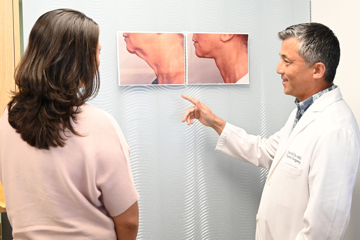 A plastic surgeon and department supervisor look at before-and-after photos of a patient's facelift.