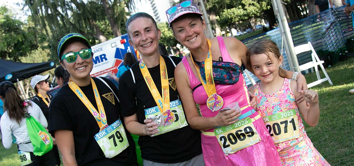 Group of women race finishers with medals.