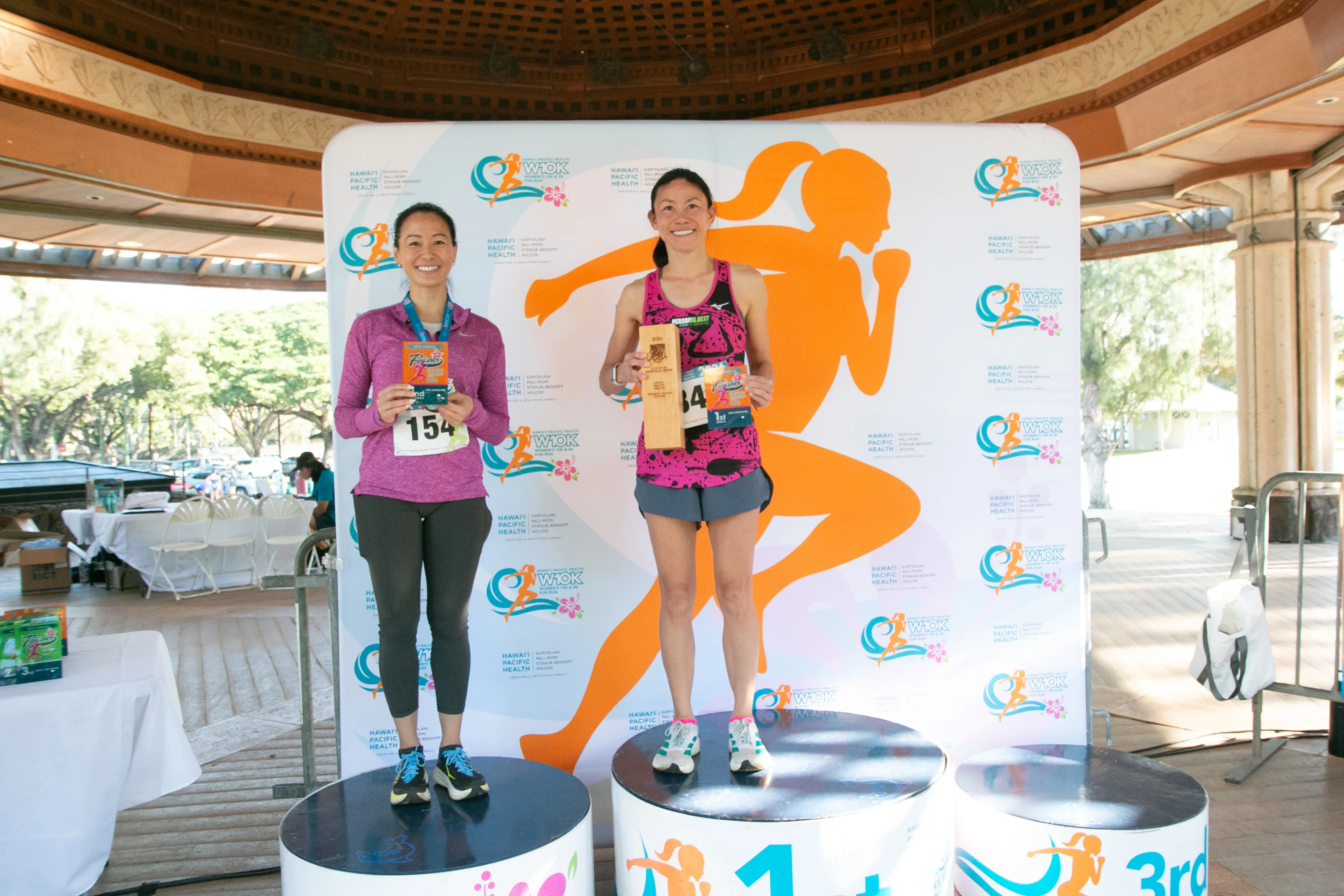 Top HPH employee finishers smiling on the winner podiums. 