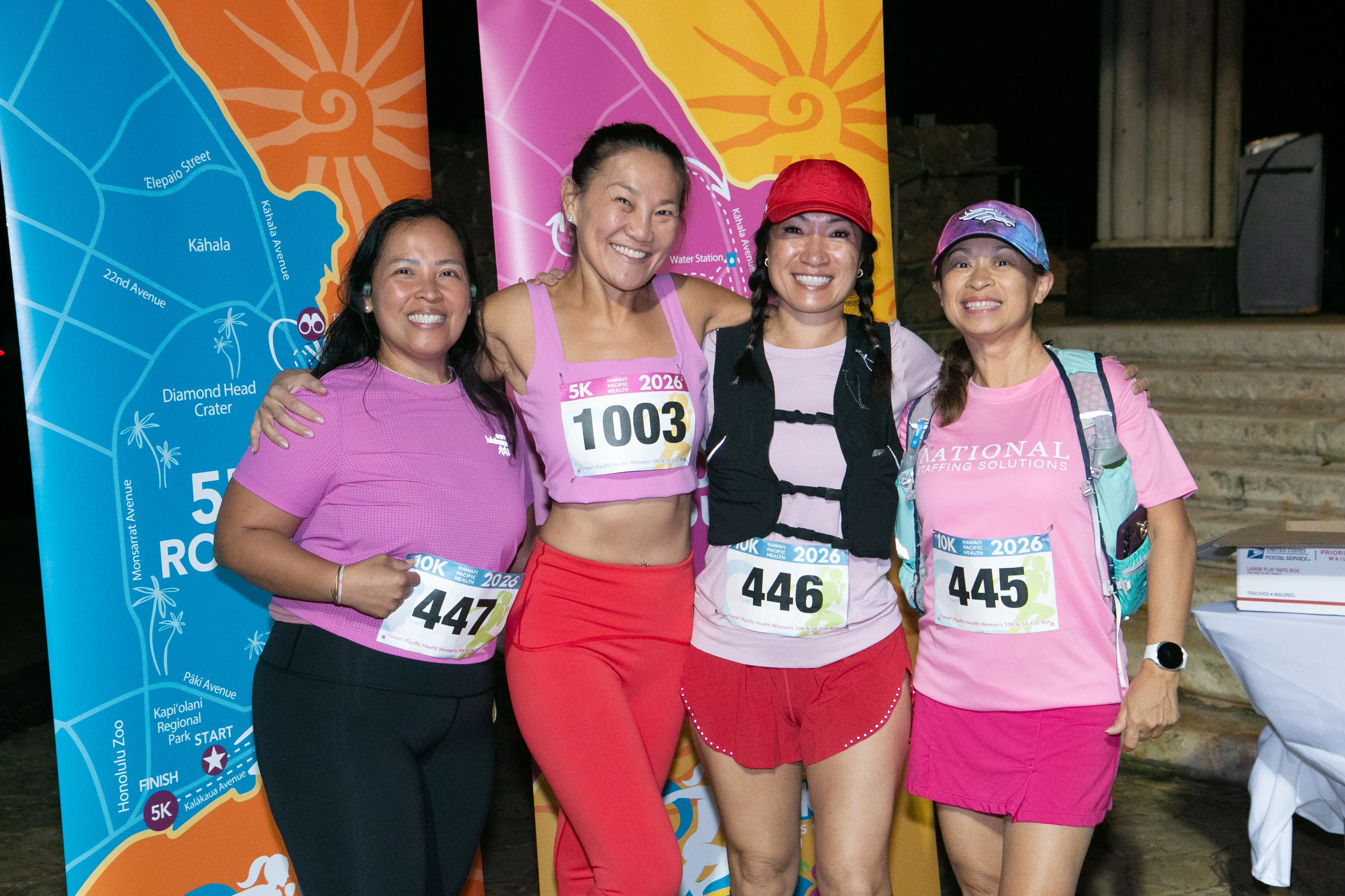 Group of women in pink running gear smiling. 