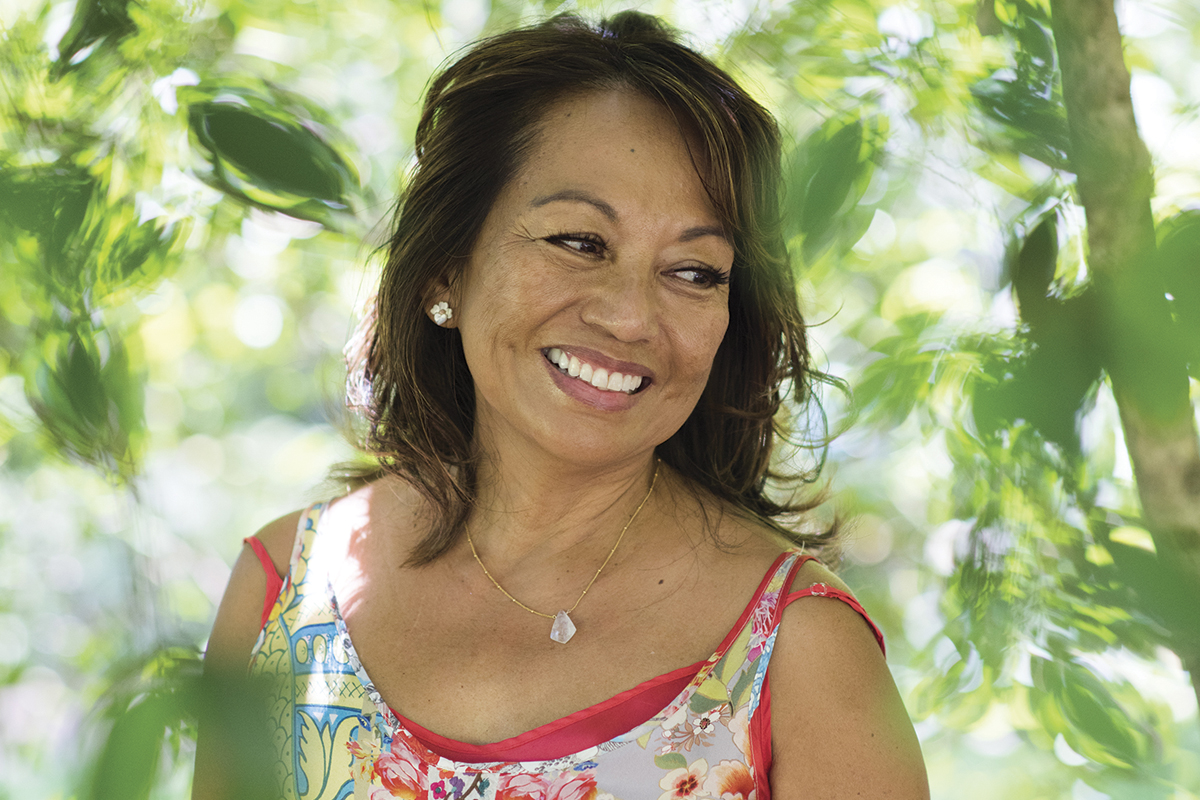 Woman smiling and standing in the forest.