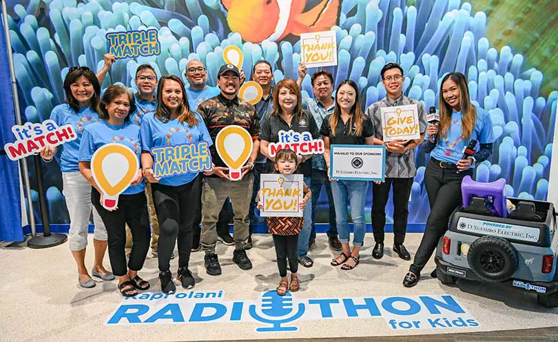Group of volunteers with signs in support of Radiothon. 