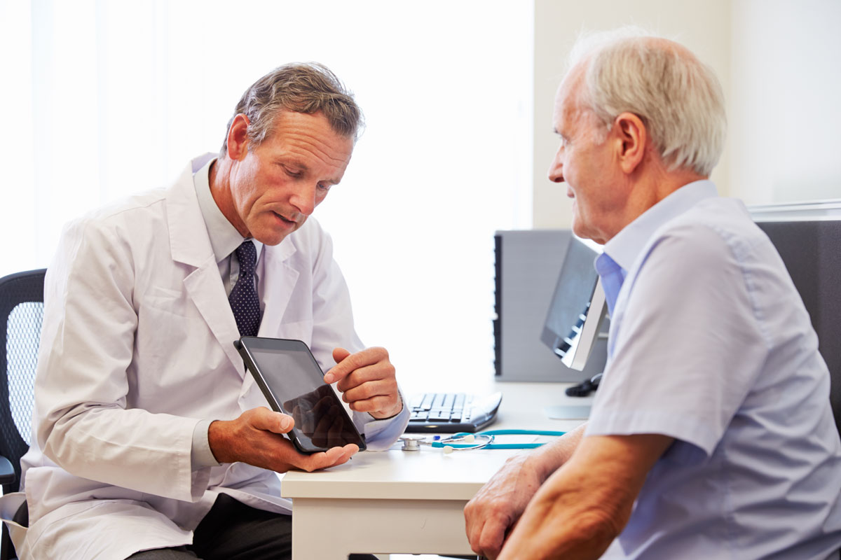 A doctor discussing treatment options with elderly man.