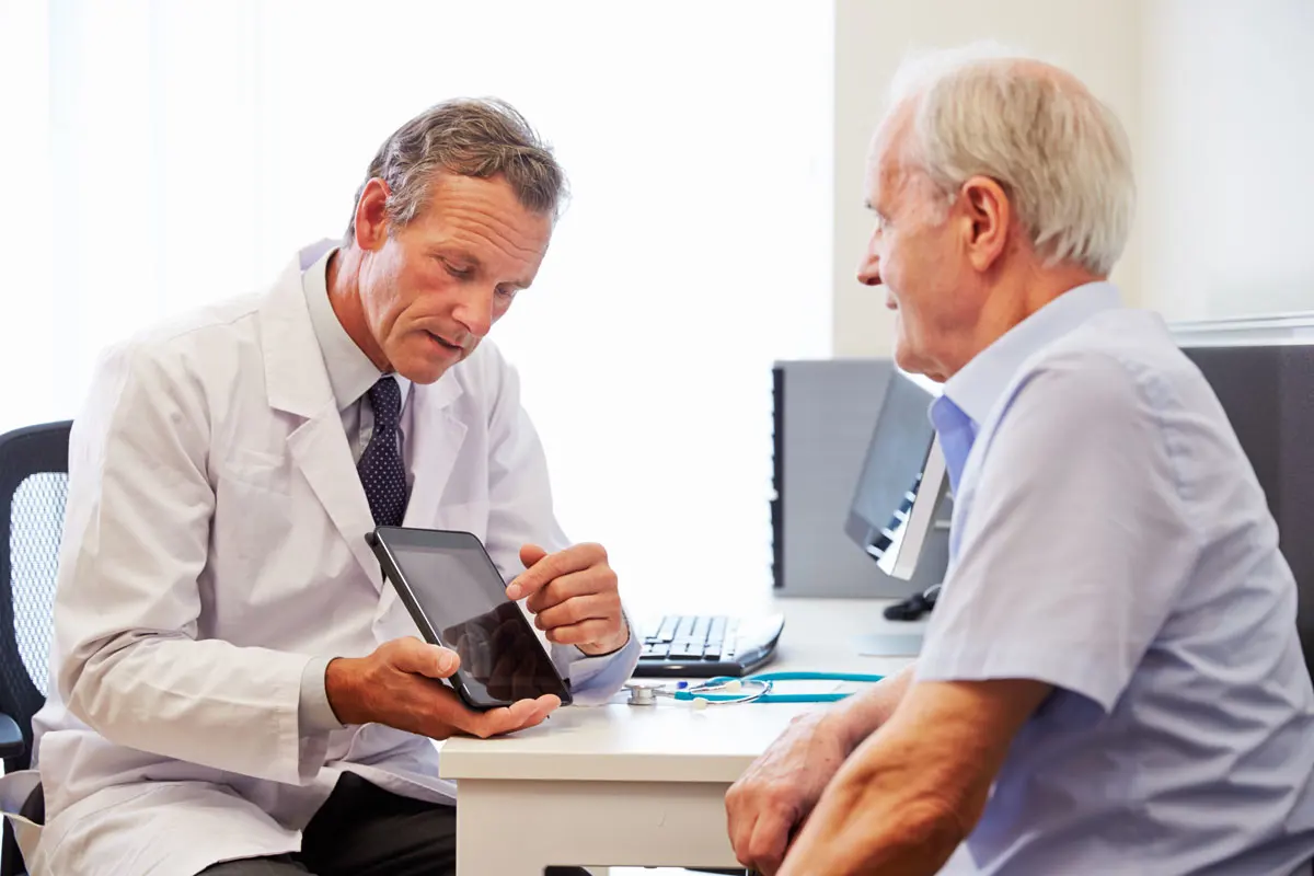 A doctor discussing treatment options with elderly man.