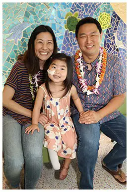 Little girl smiling with her parents.