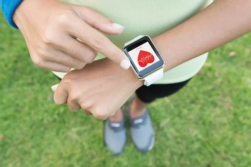 A person checks their smart watch for hteir heart rate as they exercise. 