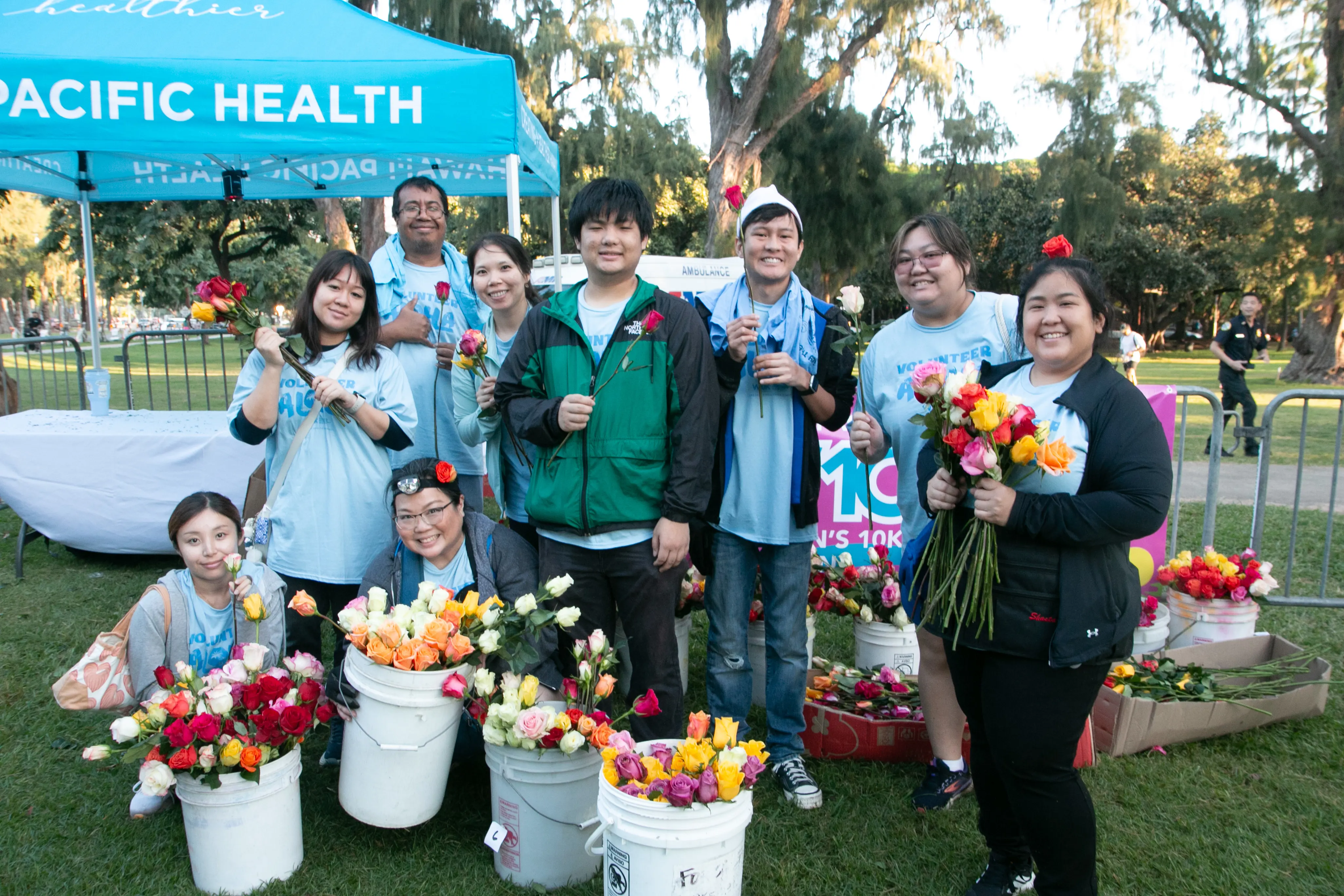 Event volunteers passing out roses to the finishers.
