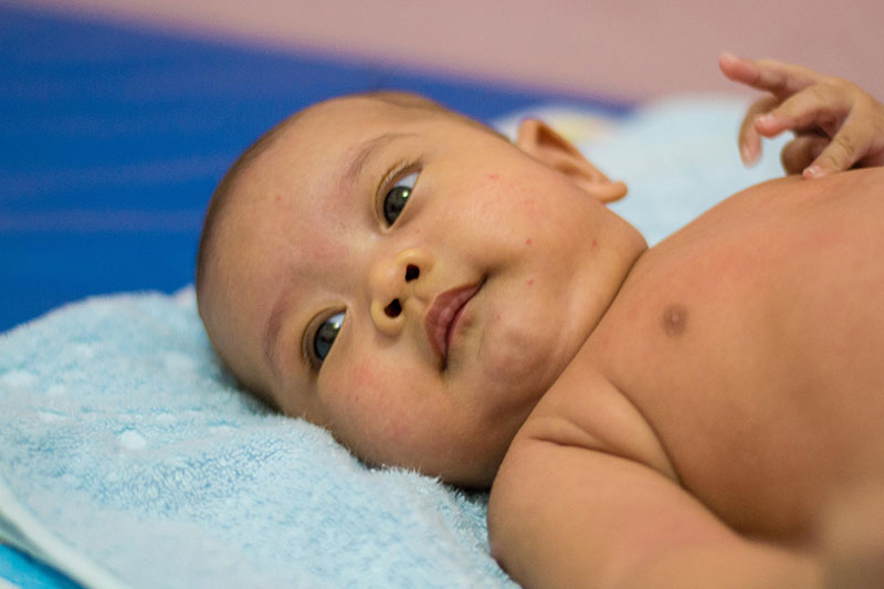Alert infant laying on their back. 